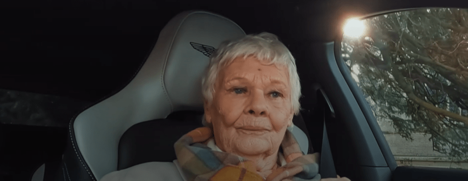 an elderly woman sits in the driver 's seat of a bentley car