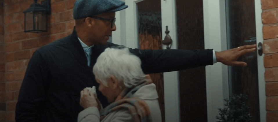 a man and woman are standing in front of a door