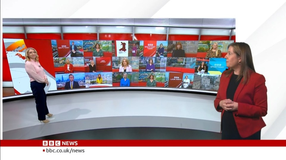 two women are standing in front of a large screen that says bbc news