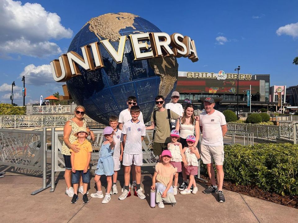 a family poses in front of the universal globe