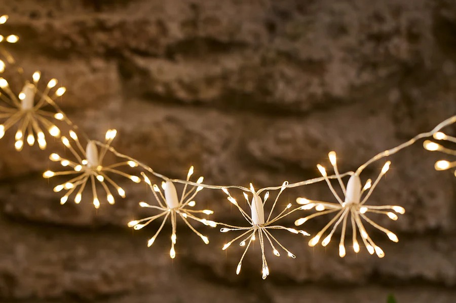 a string of lights with a brick wall in the background