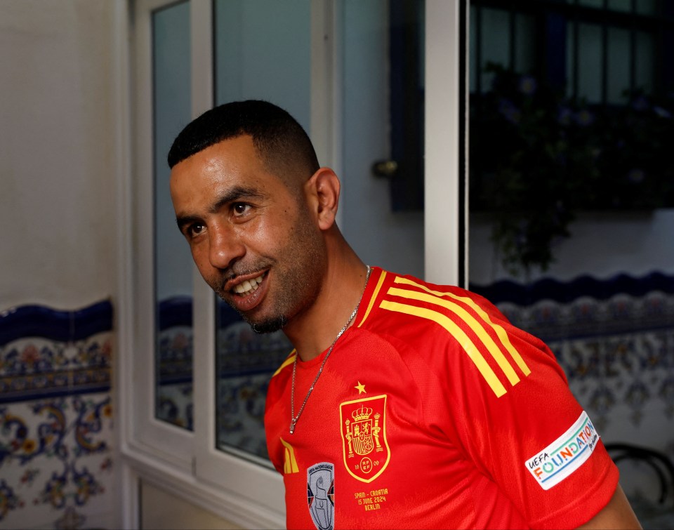 a man wearing a red shirt that says ' espana ' on it