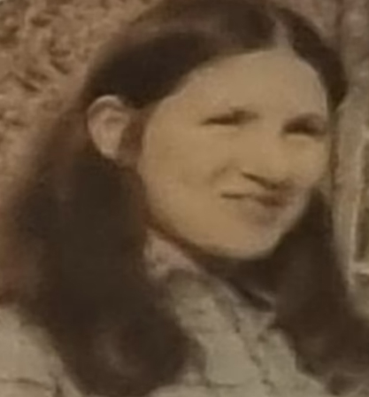 a woman with long hair is smiling in a black and white photo .