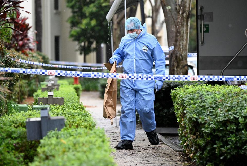 a man in a blue suit with a badge that says ' forensics ' on it