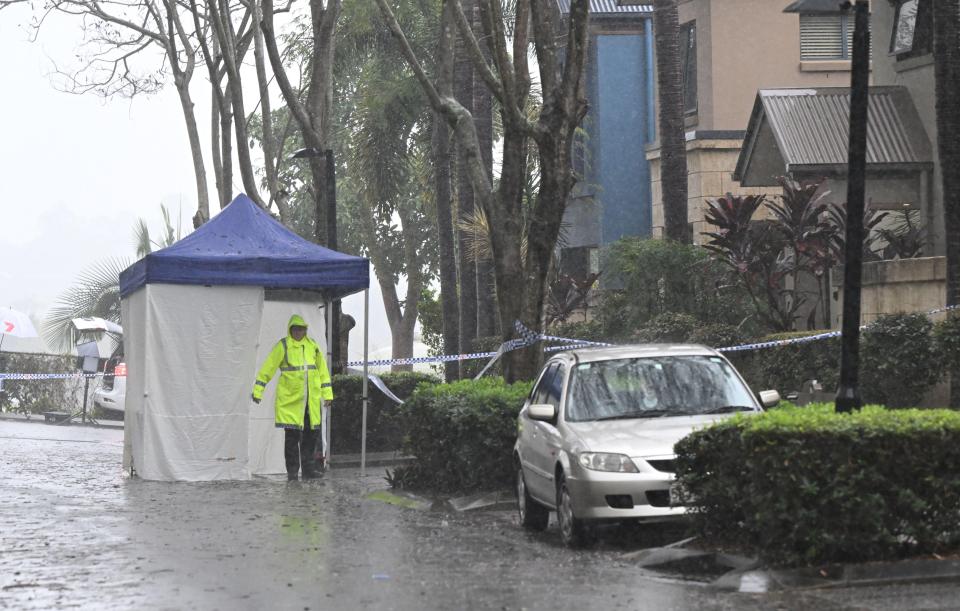 a man in a yellow raincoat stands in front of a white tent