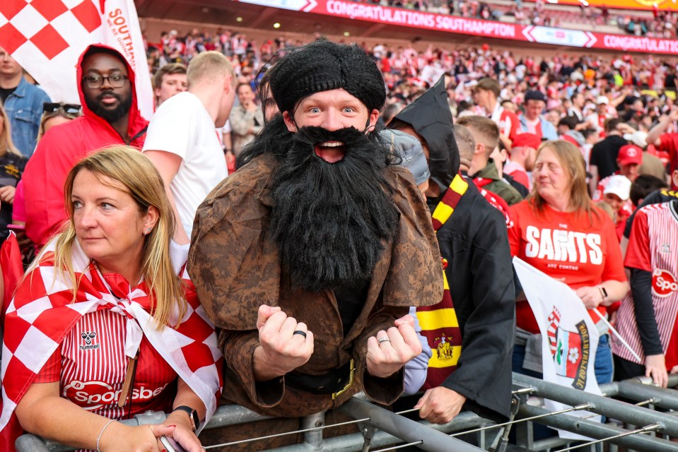 a man with a beard wears a saints shirt