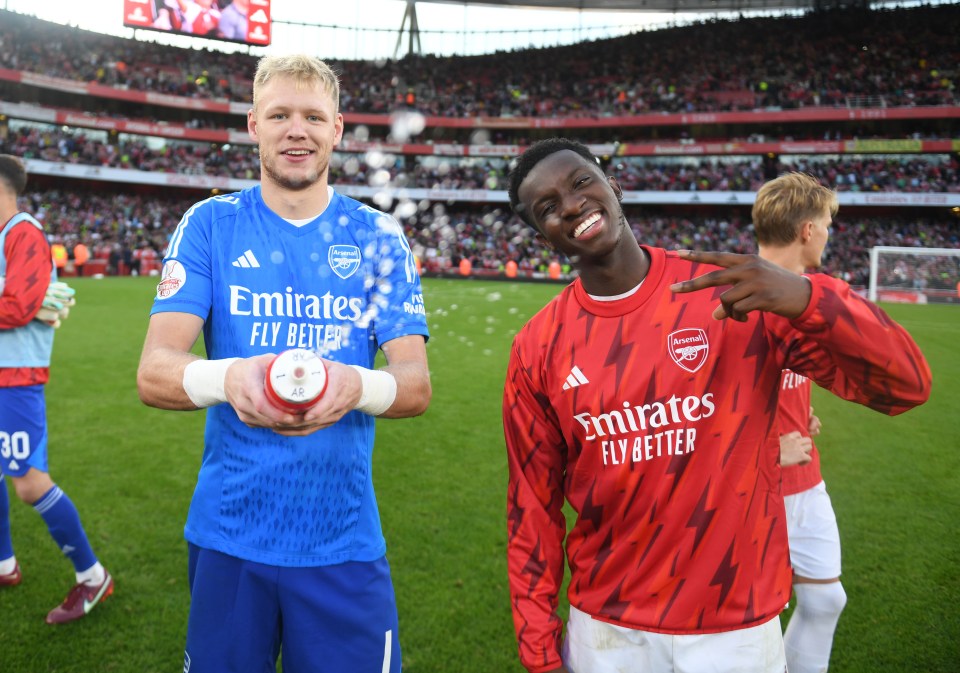 two soccer players wearing emirates fly better jerseys pose for a picture