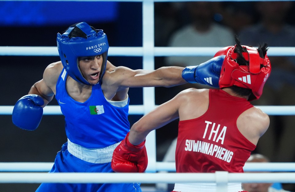 two boxers in a ring with one wearing a paris 2004 helmet