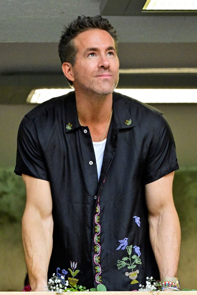 a man wearing a black shirt with flowers on it