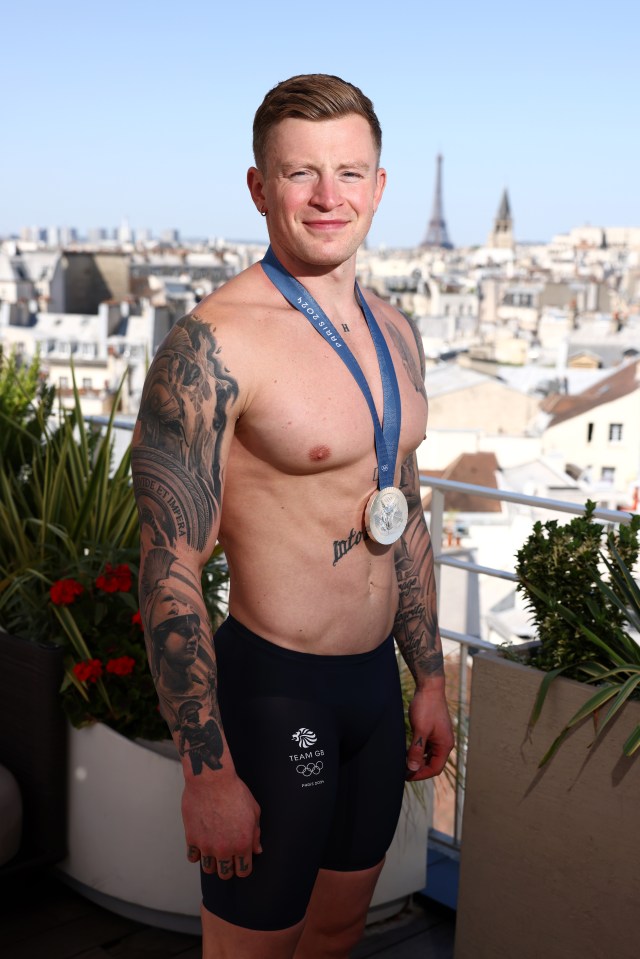 a shirtless man with a medal around his neck that says tokyo 2020