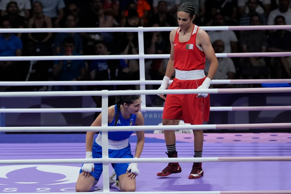 a female boxer kneeling down in a boxing ring