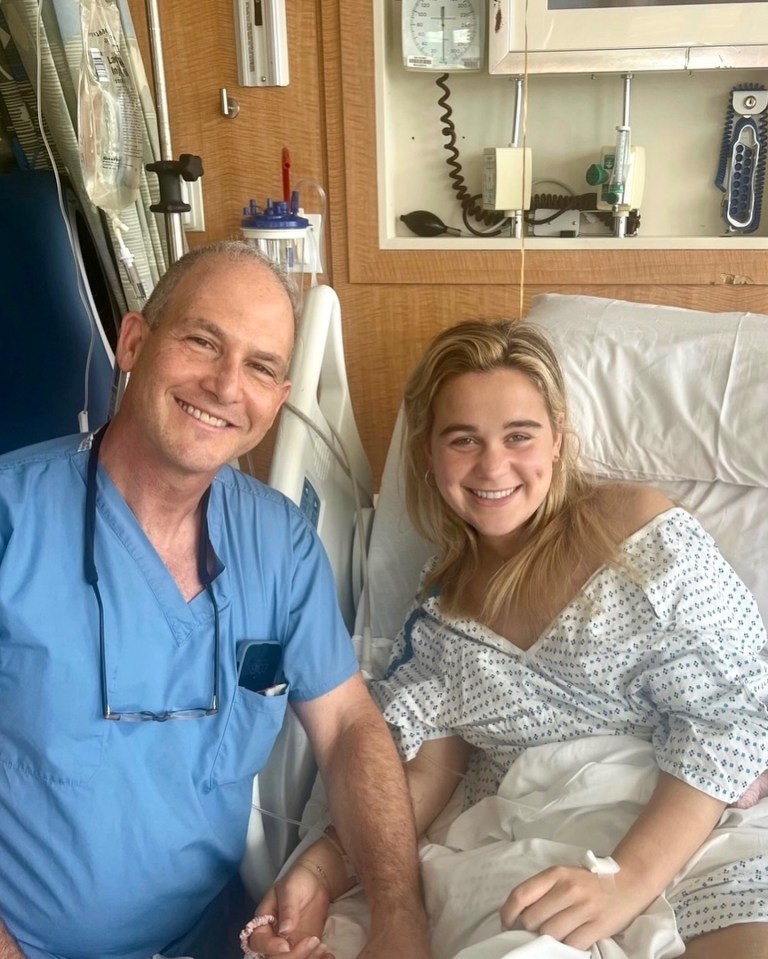 a man in scrubs sits next to a woman in a hospital bed