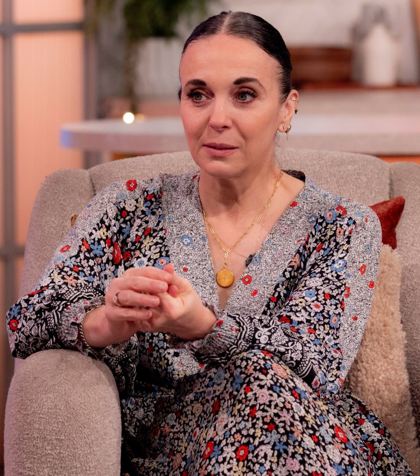 a woman in a floral dress sits in a chair with her hands folded