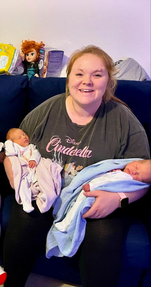 a woman wearing a disney cinderella shirt holds two babies