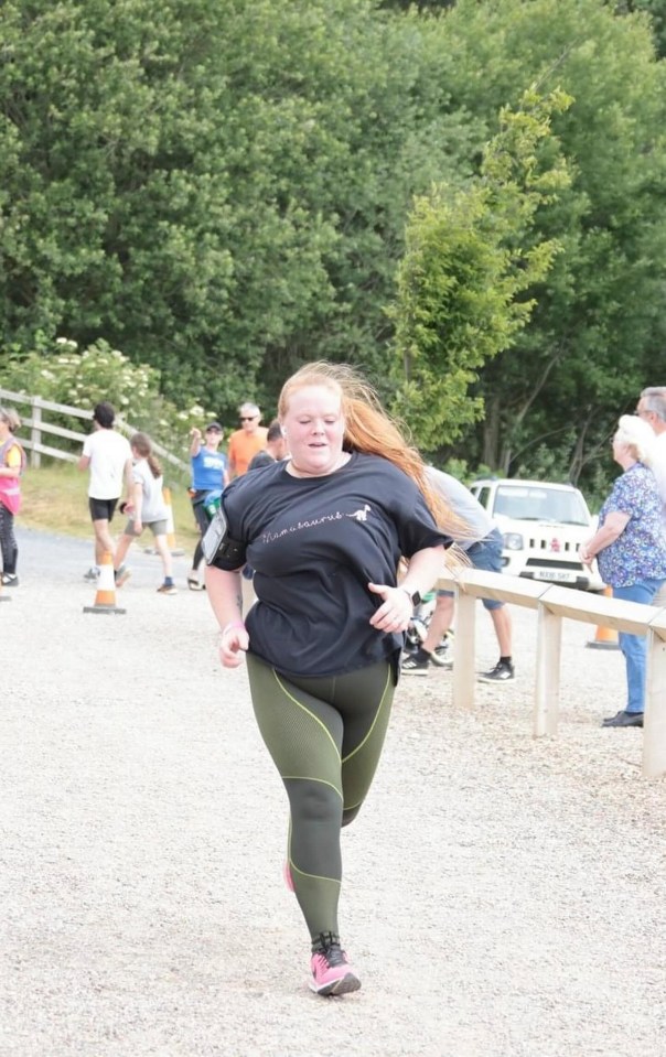 a woman wearing a black shirt that says team hunt is running