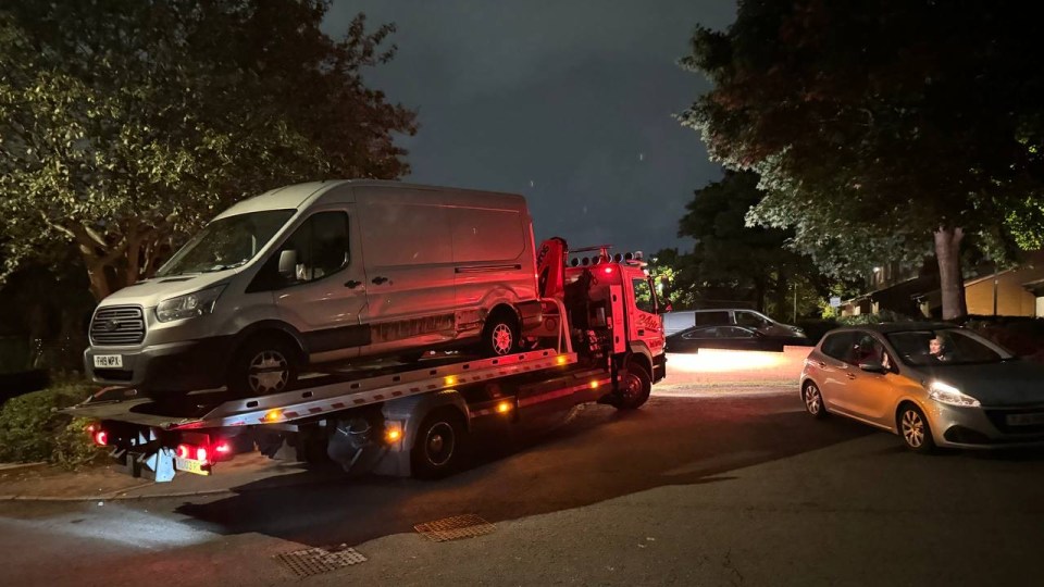 a white van is being towed by a tow truck