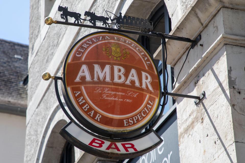 a sign for ambar cerveza especial hangs from the side of a building