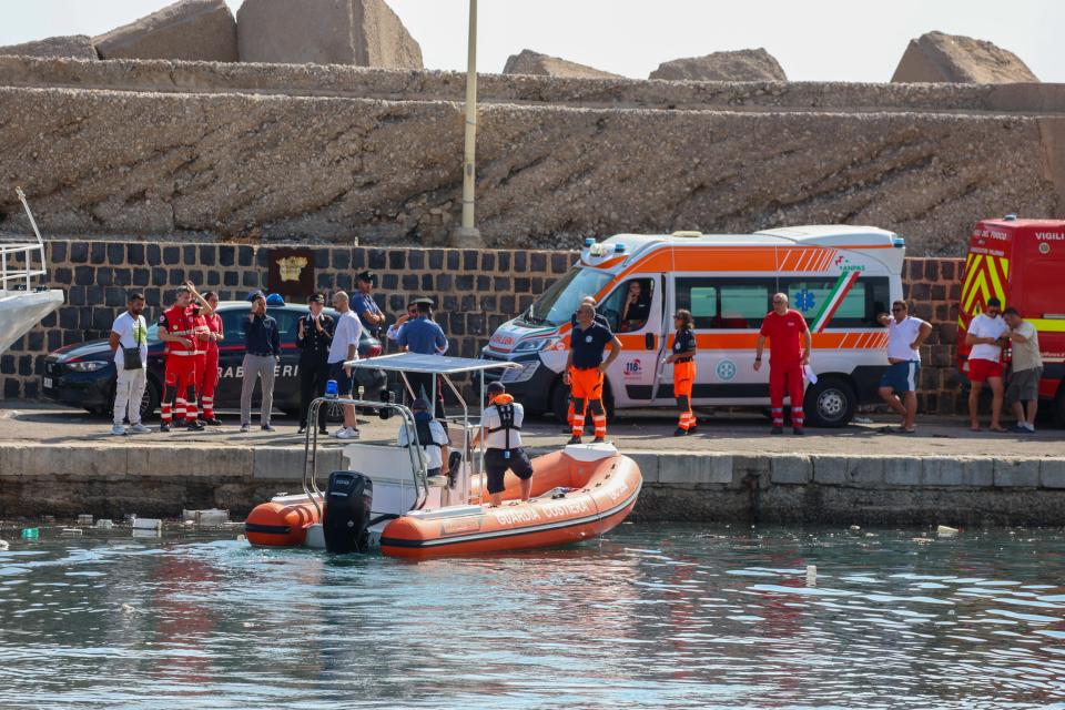 Ambulances with health workers wait on the pier