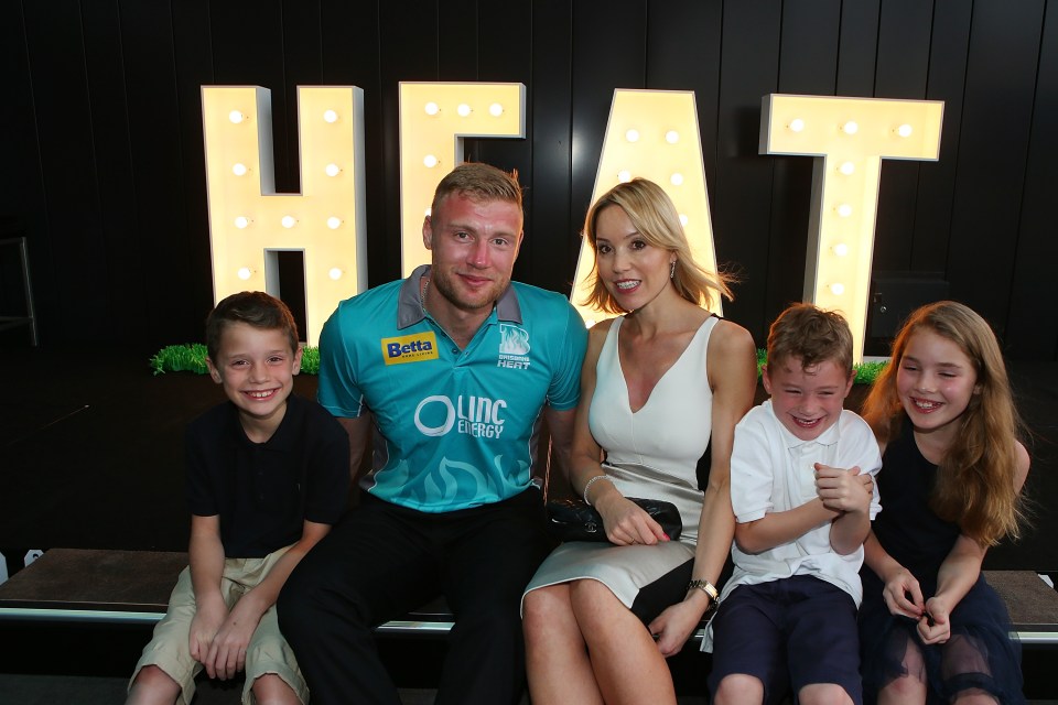 a woman wearing a virgin jersey sits next to a man and two children