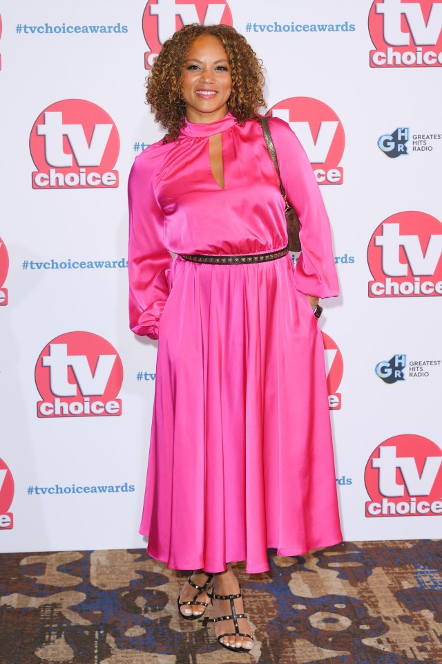 a woman in a pink dress stands in front of a tv choice sign