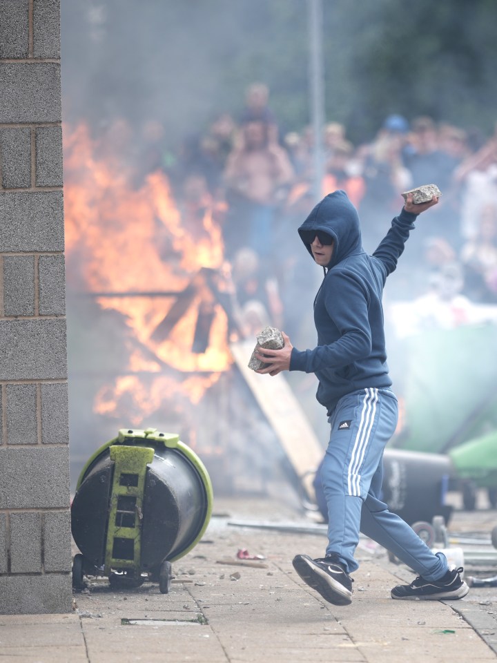 A far-right yob throwing bricks during the Rotherham protests