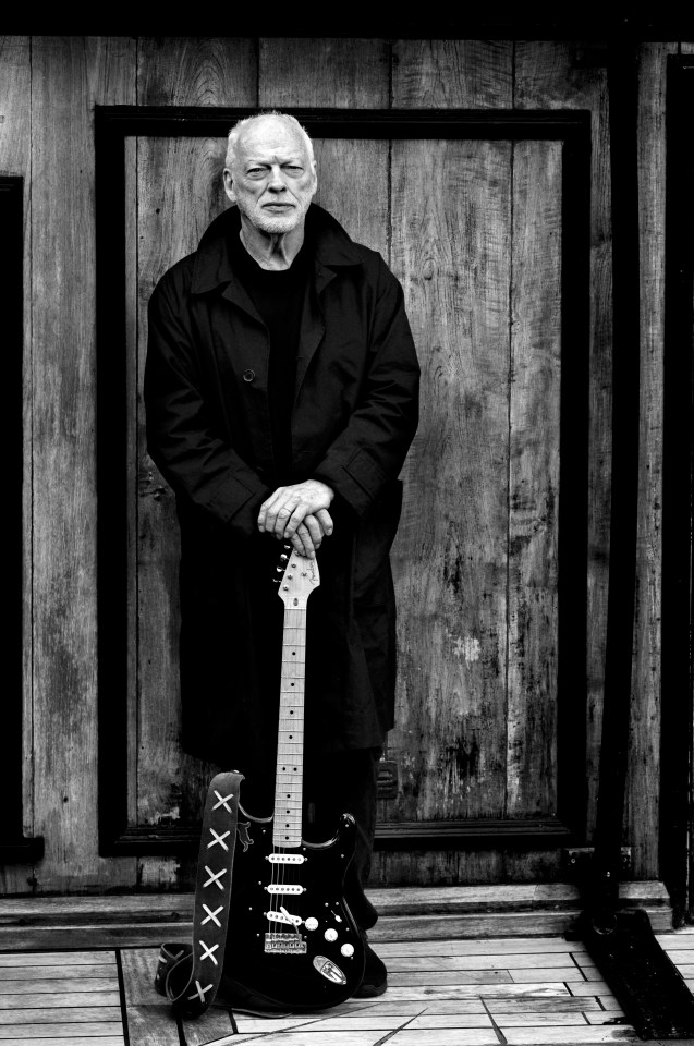 a black and white photo of a man holding a guitar