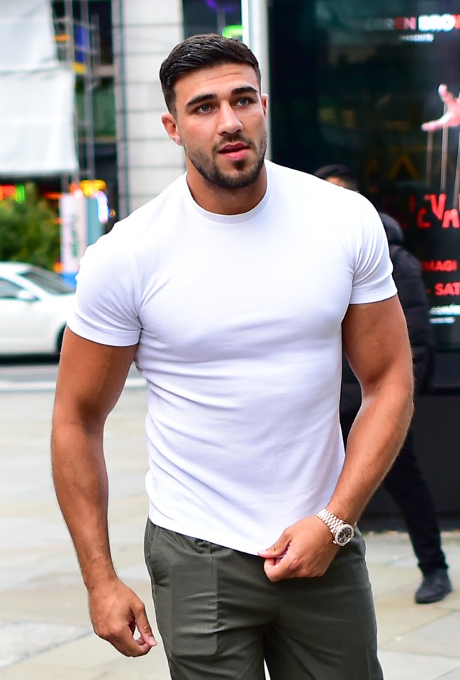 a man wearing a white t-shirt and green pants