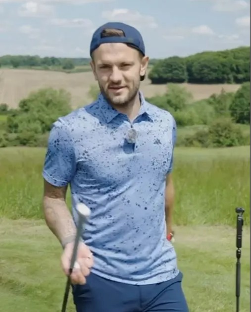 a man in a blue shirt is holding a golf club