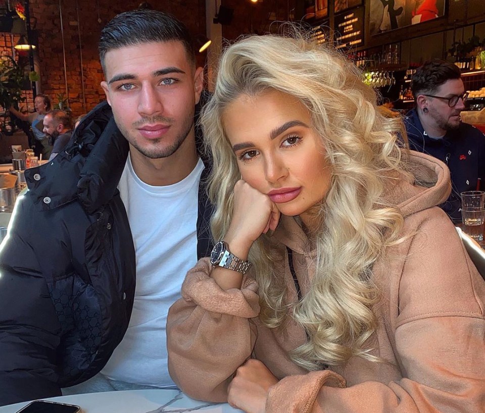 a man and a woman are posing for a picture in a restaurant