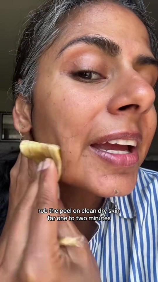 a woman is rubbing the peel on her face for one to two minutes .