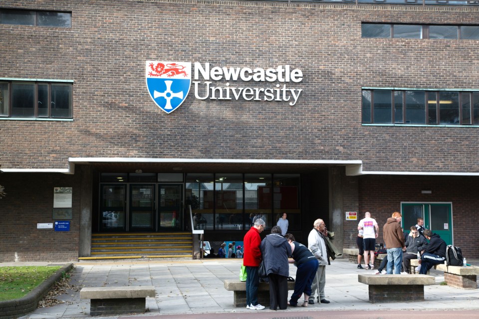 a group of people standing outside of a newcastle university building