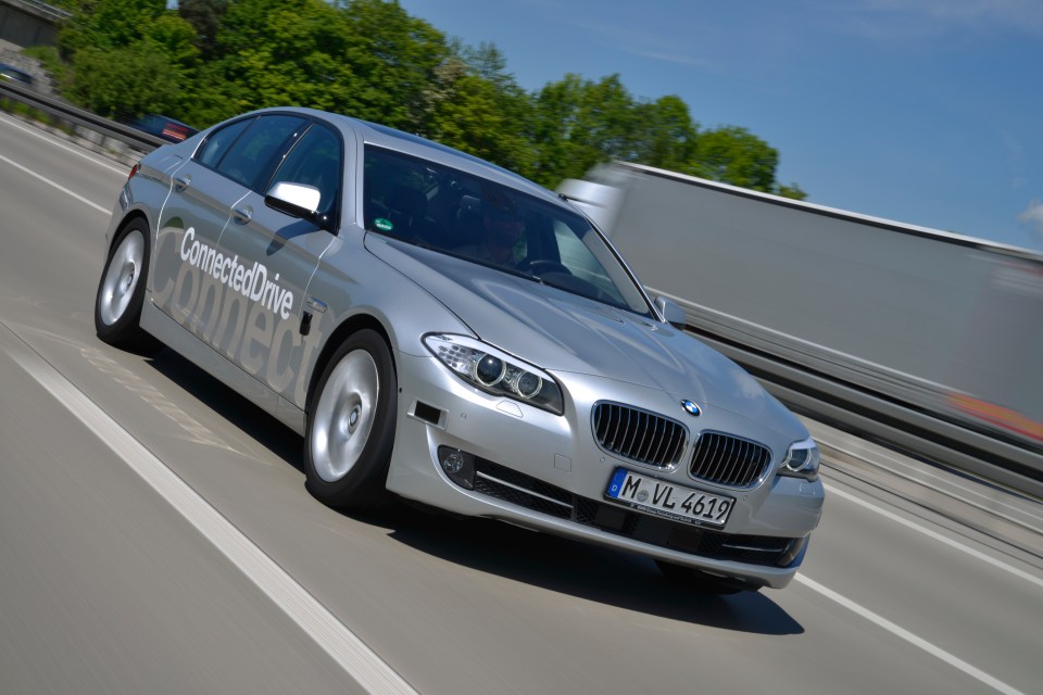 a silver connecteddrive car is driving down a highway