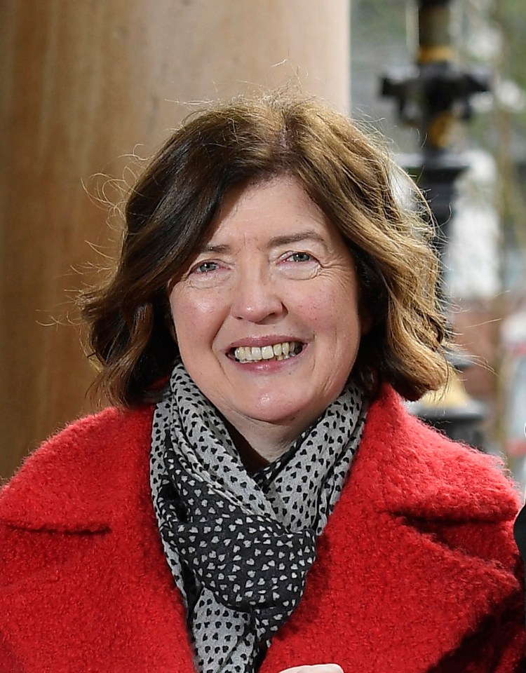 a woman in a red coat and scarf smiles for the camera