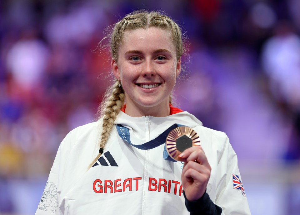 a woman holding a medal that says great britain on it