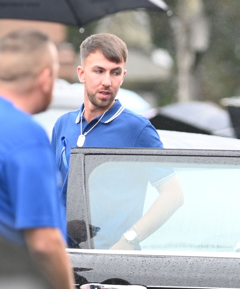 a man in a blue shirt is getting out of a car