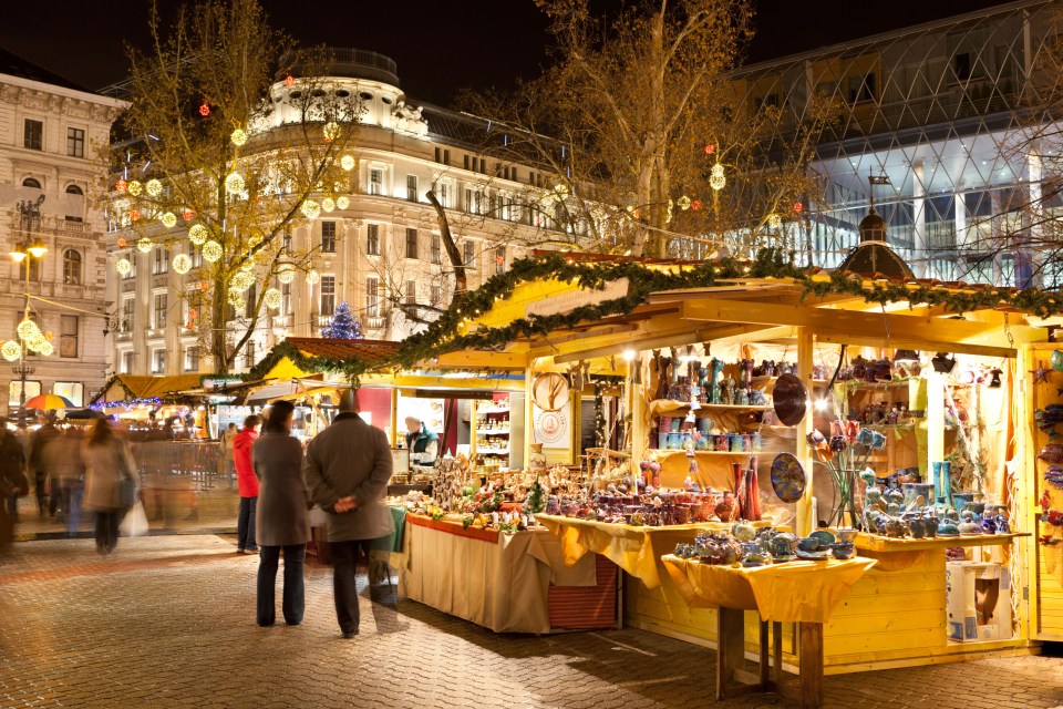 a couple standing in front of a christmas market