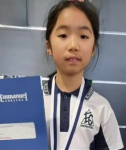 a young girl wearing a medal and a certificate from emmanuel college