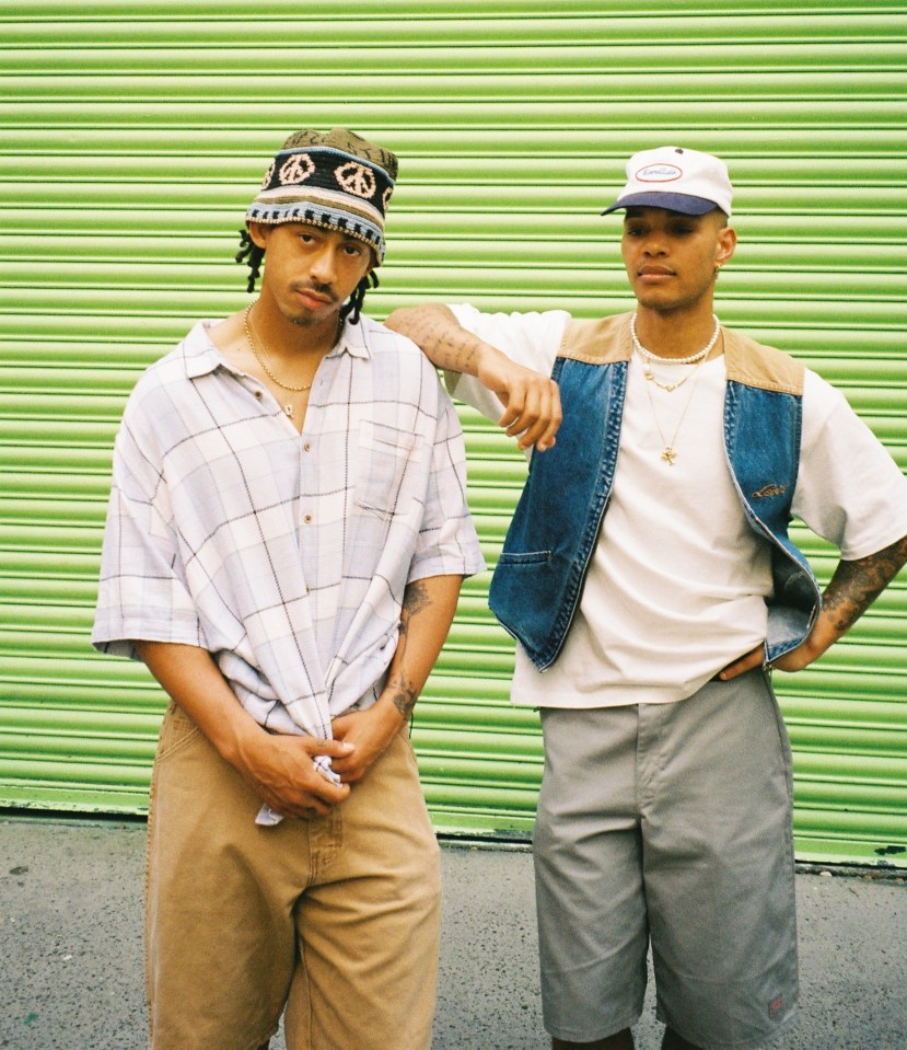 two men standing next to each other with one wearing a peace sign headband