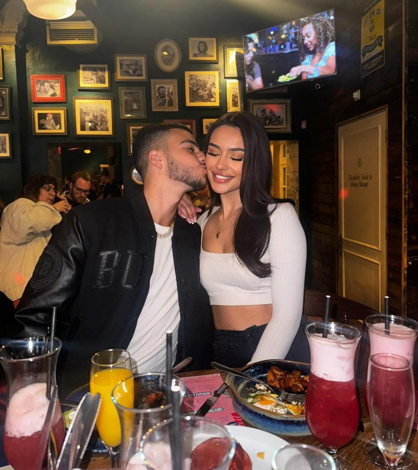 a man kisses a woman on the cheek in a restaurant