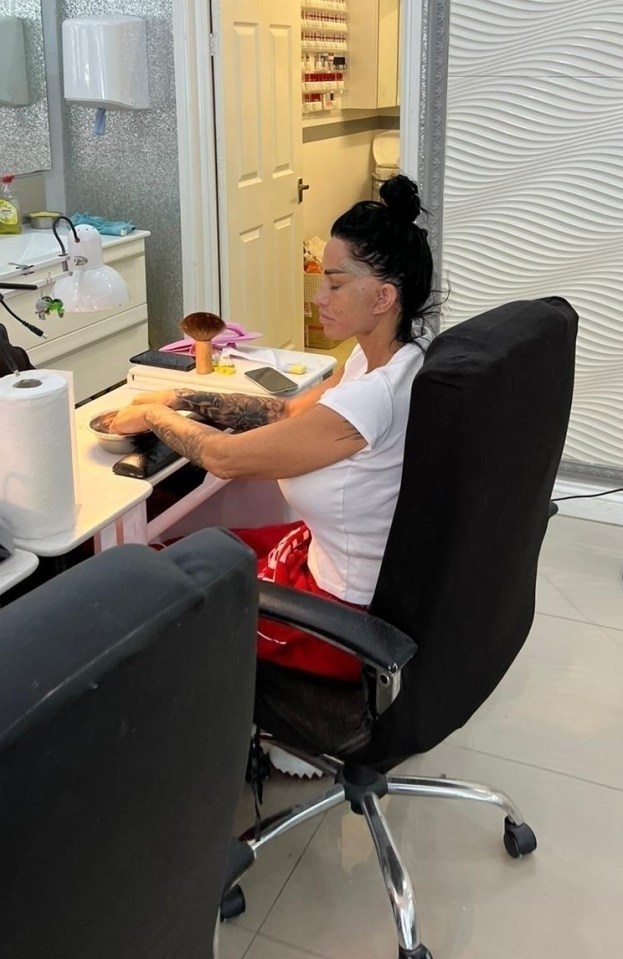 a woman sits in a chair in a nail salon