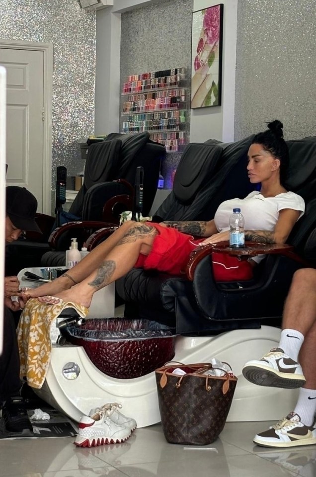 a woman sits in a chair with a bottle of water on her lap