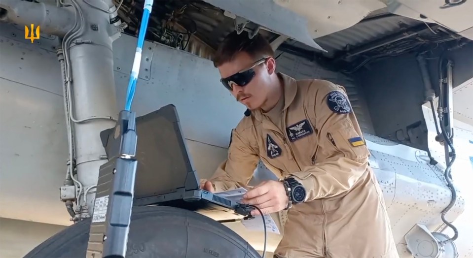 a man in a military uniform is working on a laptop