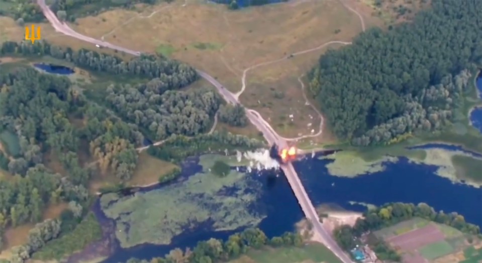 an aerial view of a bridge over a river with the letter l on the bottom right