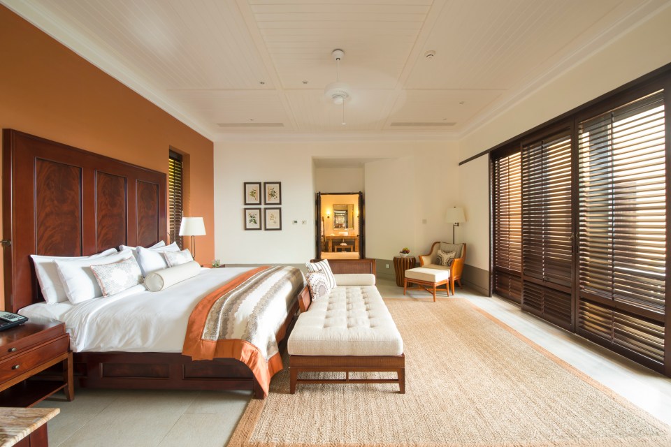 a bedroom with a large bed and wooden blinds