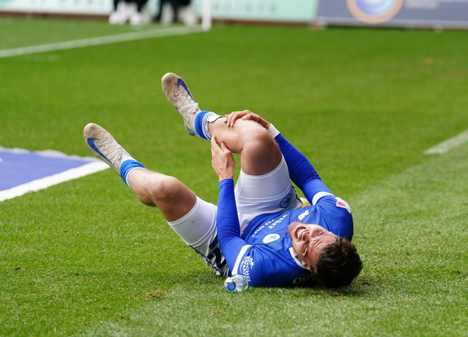 a soccer player is laying on the ground with his knee in pain