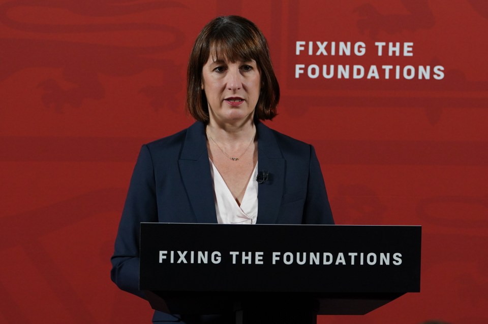 a woman stands behind a podium that says fixing the foundations