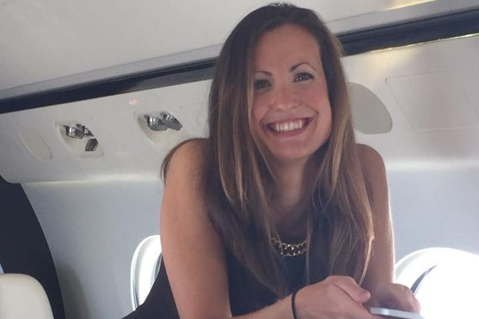 a woman in a black dress is smiling in an airplane