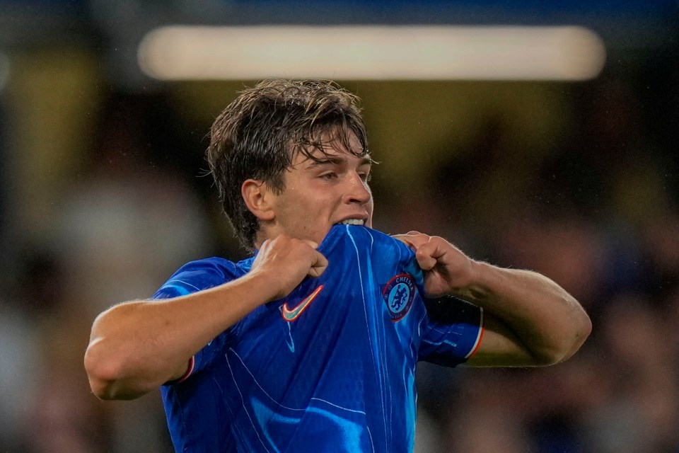 a man wearing a blue shirt with the word chelsea on it