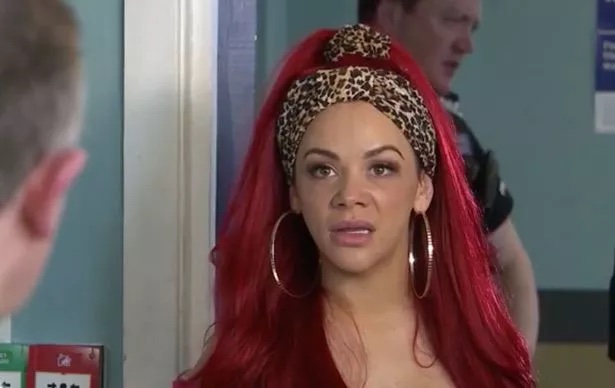 a woman with red hair is wearing a leopard print headband and hoop earrings .