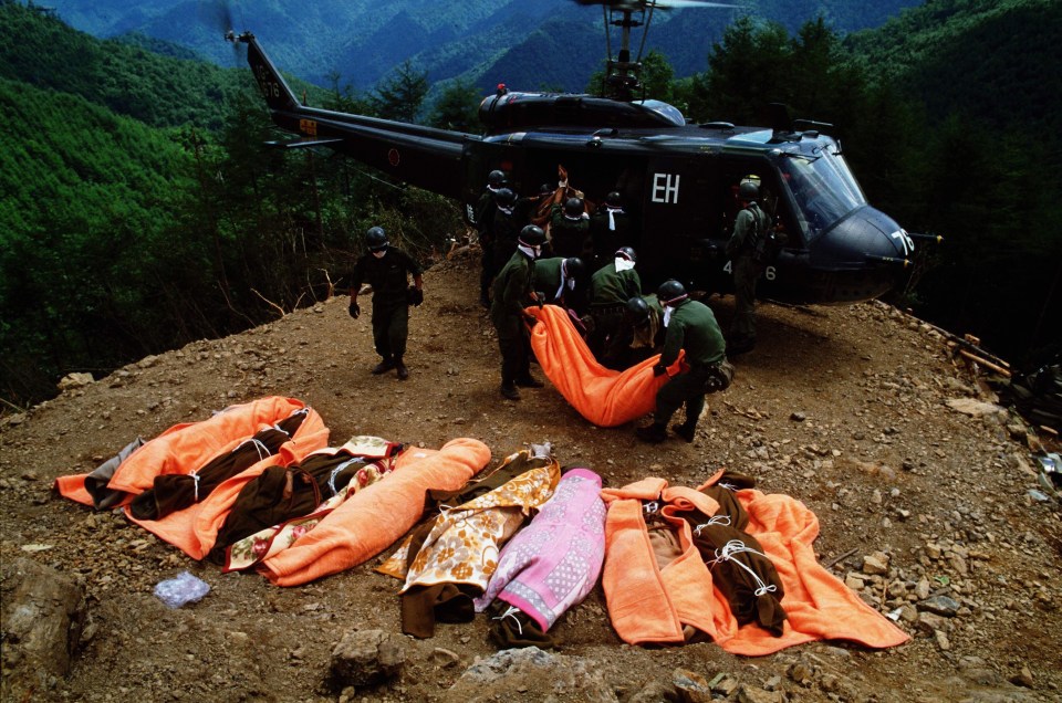 Members of the Japan Ground Self-Defense Force carry bodies by a helicopter at the ridge of Mount Osutaka on August 14, 1985